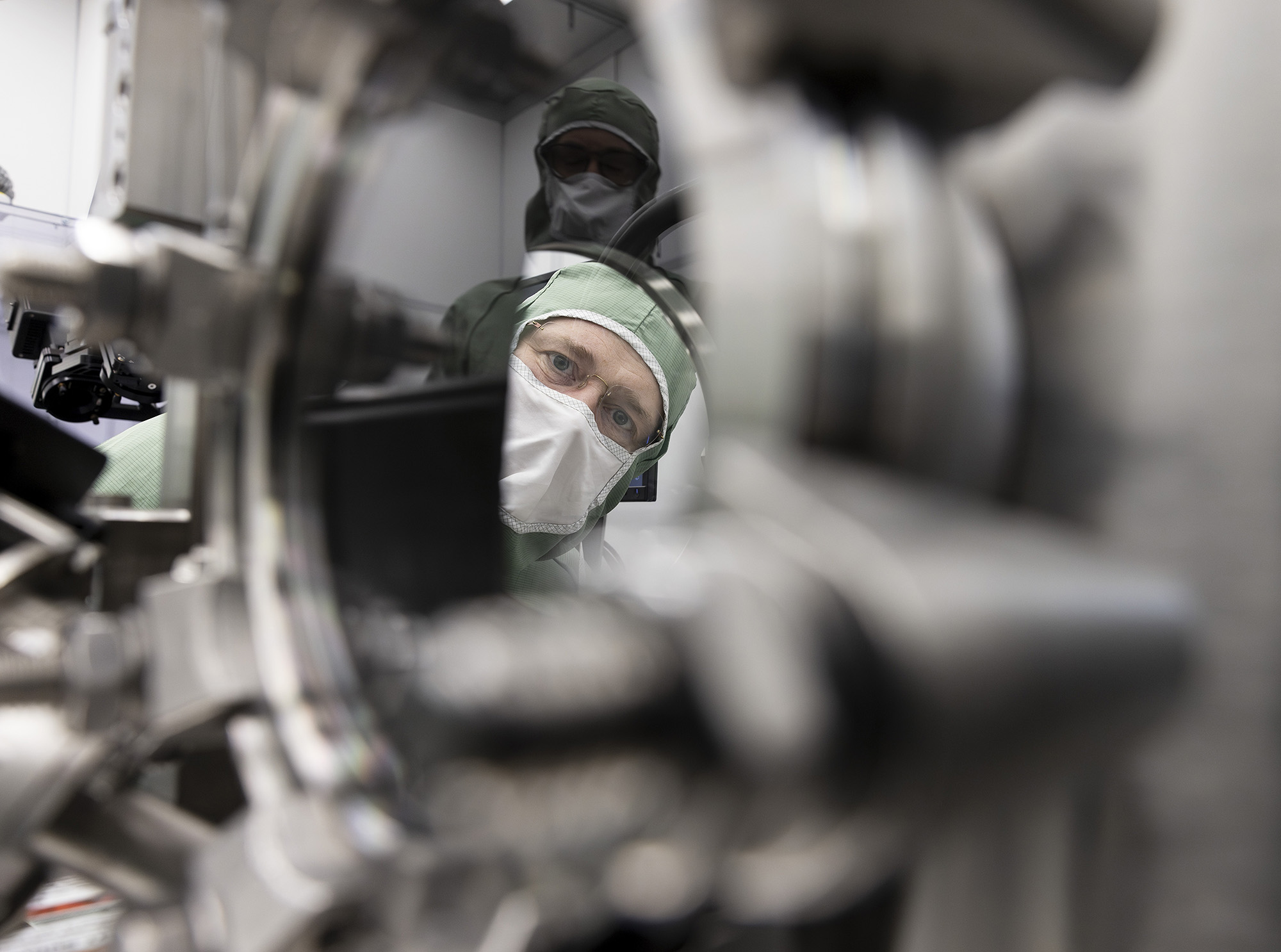 Closeup of machine, through which you see a person wearing protective gear