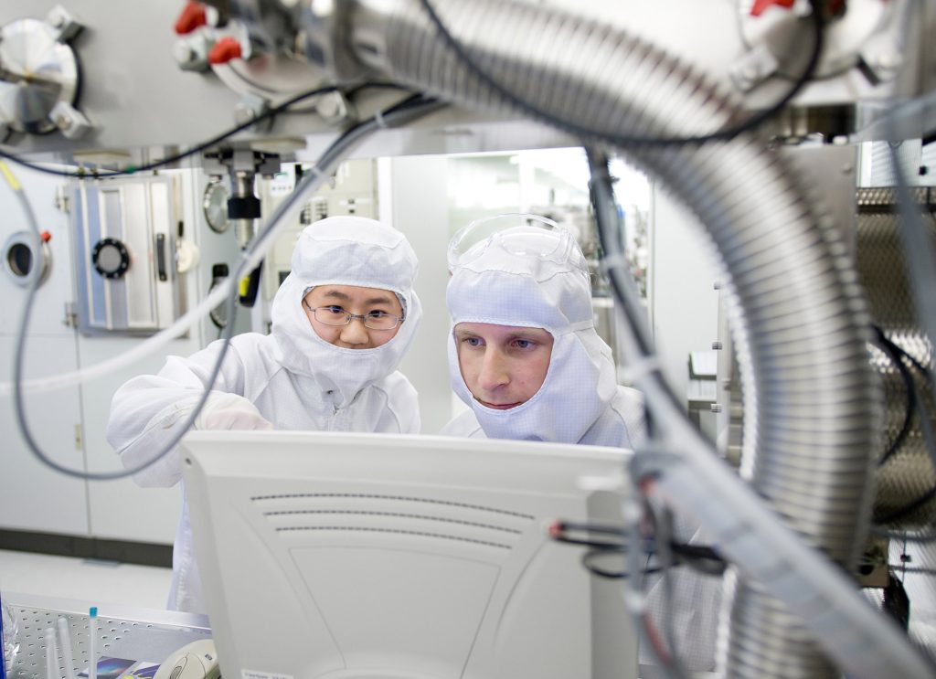 Cleanroom MC2, two people wearing protective gear and looking at a screen