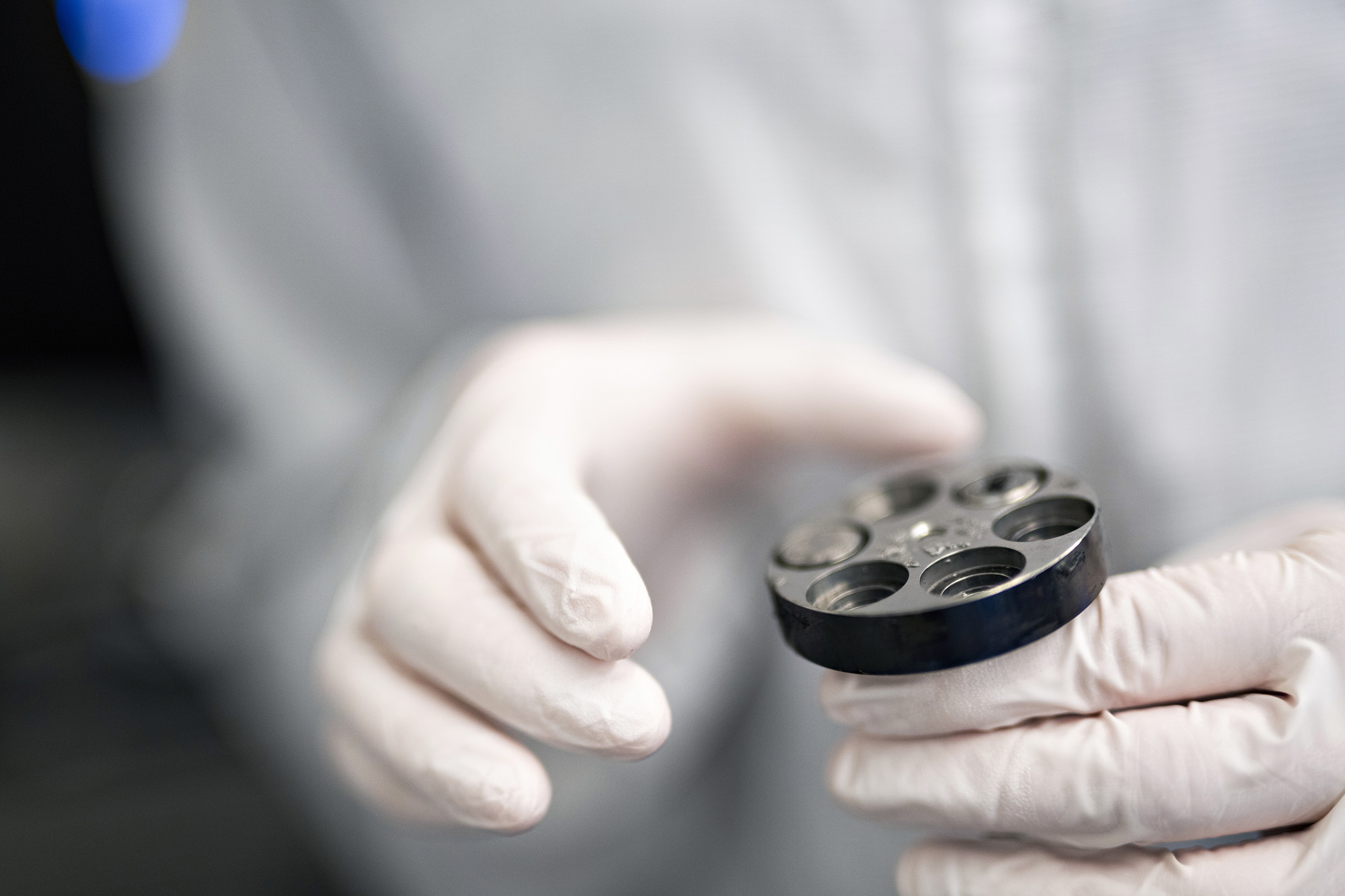 Closeup image of someone handling object while wearing protective gloves